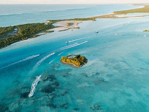Aerial view of boats and jetskis passing by Star Island