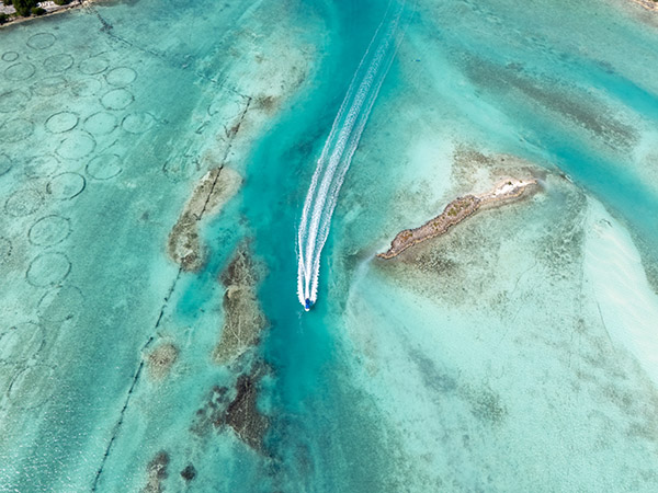 Boat Near Conch Farm Pools in Shallow Turquoise Waters
