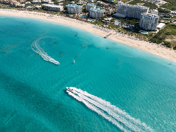 Drone shot of boats passing in front of Ritz-Carlton Resort and Seven Stars Resort