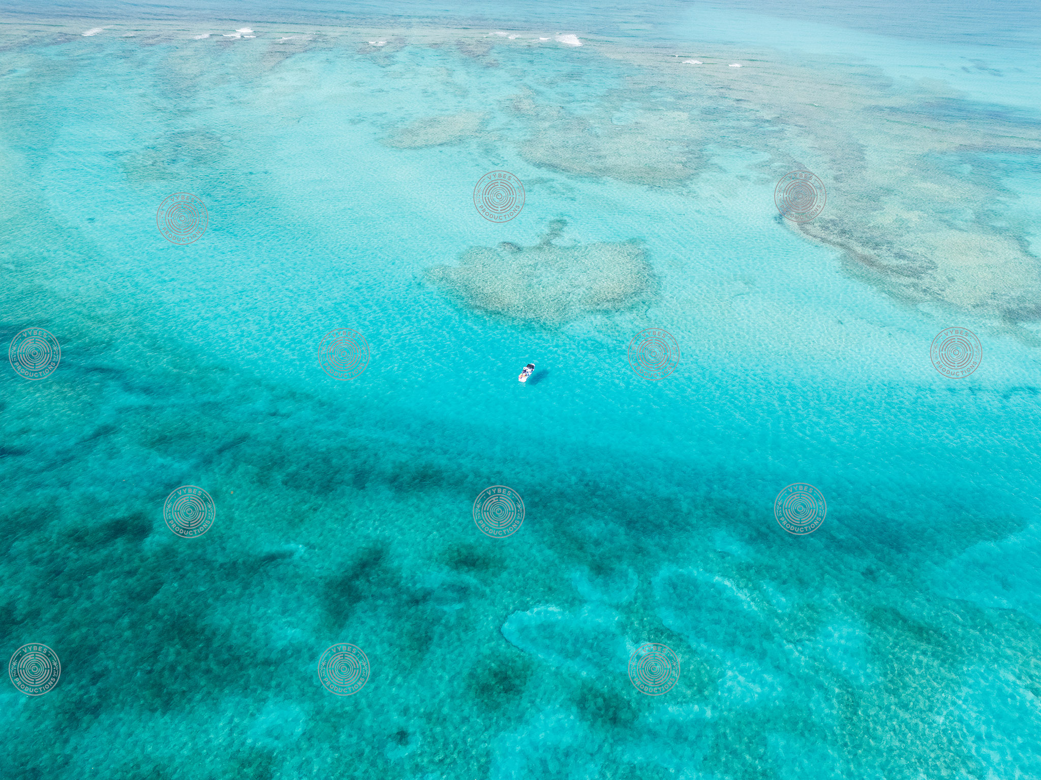 Drone shot of boat anchored in vibrant Grace Bay waters