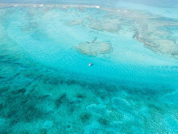 Drone shot of boat anchored in vibrant Grace Bay waters