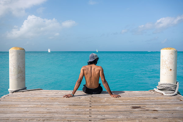 Tourist looking out into Grace Bay waters near Rickies