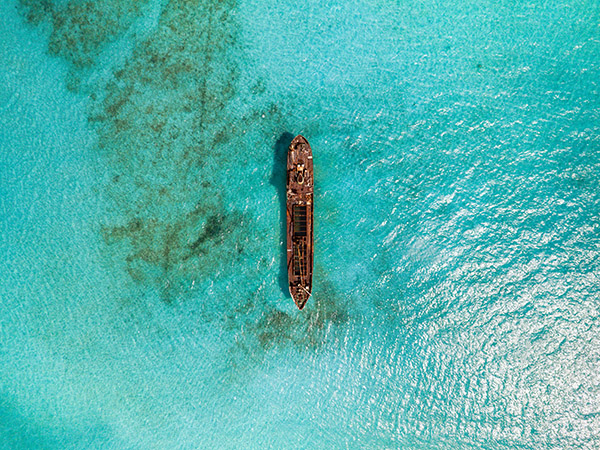 Top-down aerial of La Famille Express shipwreck in turquoise water
