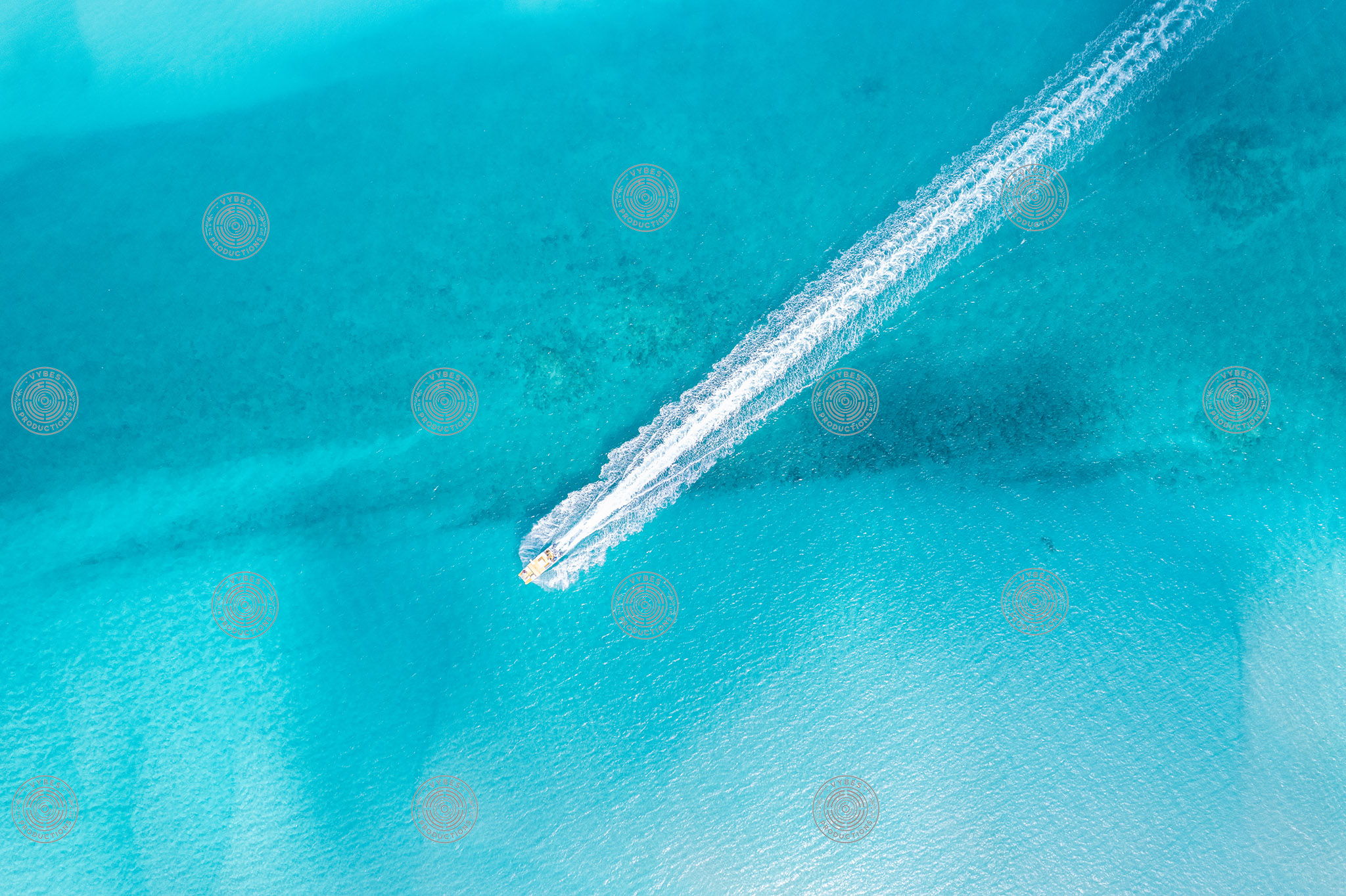 Drone shot of boat cruising across Grace Bay waters