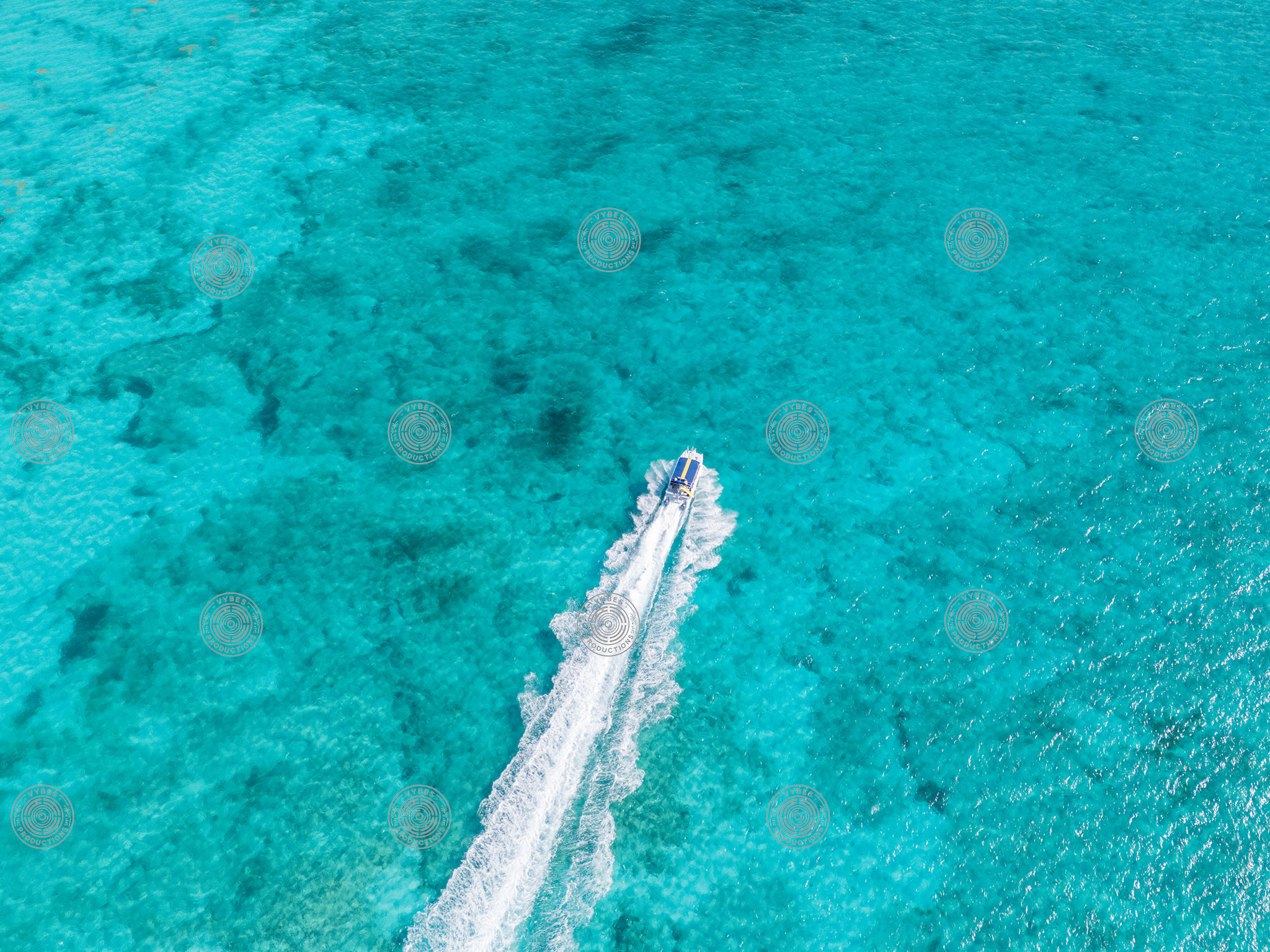 Tour boat leaving trail through clear Grace Bay water