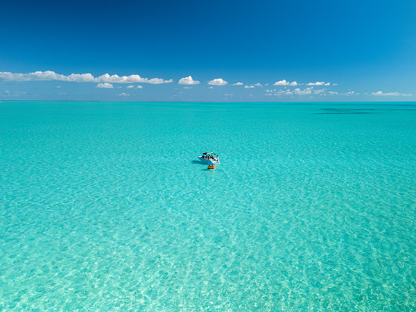 Small boat with tube floating near Long Bay