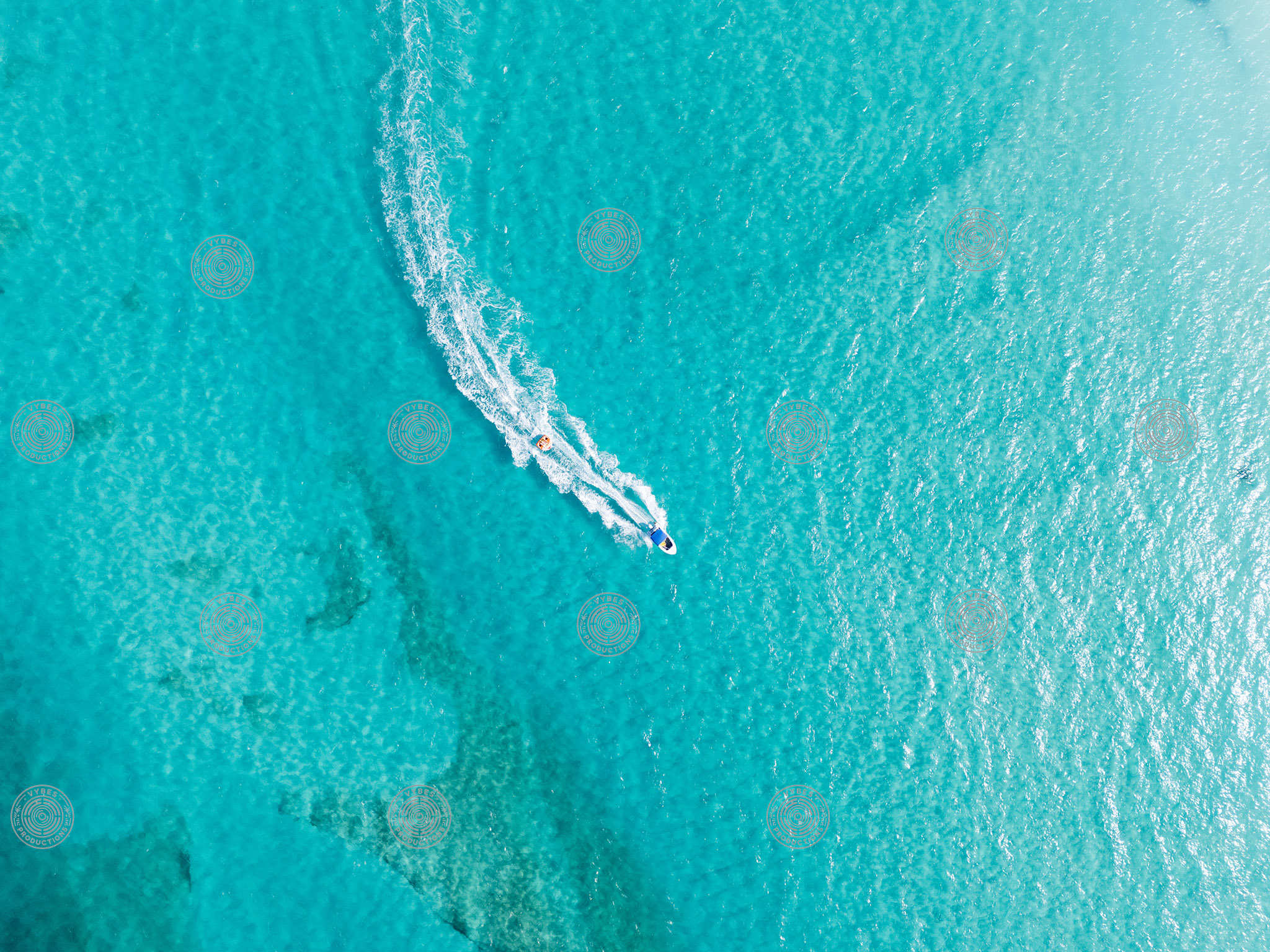 Top down drone shot of boat pulling tube