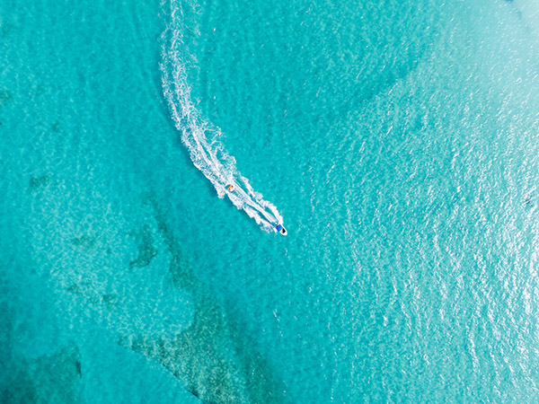 Top down drone shot of boat pulling tube
