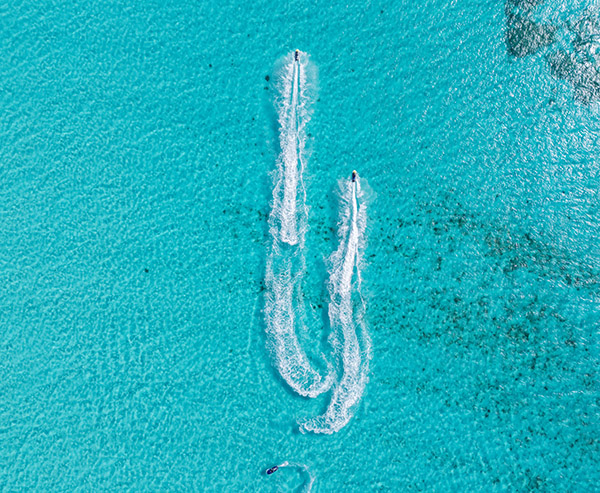 Two Jet Skis Creating Wake Trails in Crystal Clear Ocean