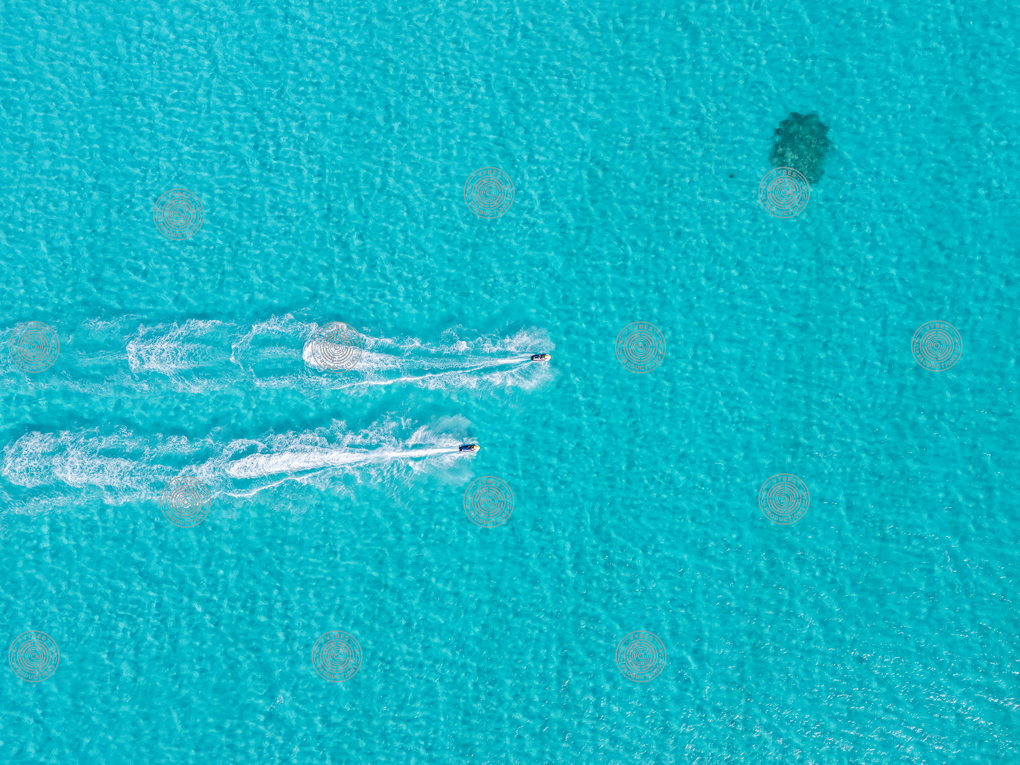 Jet Skis Racing Side by Side in Shallow Blue Water, Top-Down View
