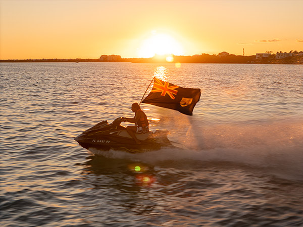 Close-up drone shot of a jetski carrying official TCI flag