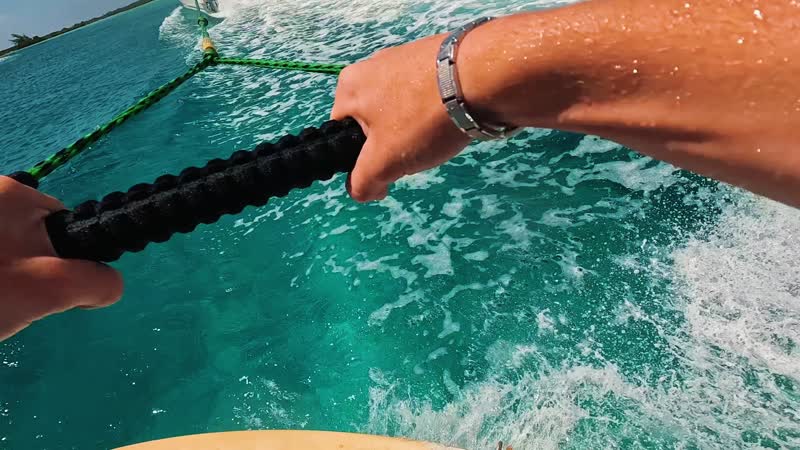 Action camera shot of tourist wakeboarding behind wakeboat