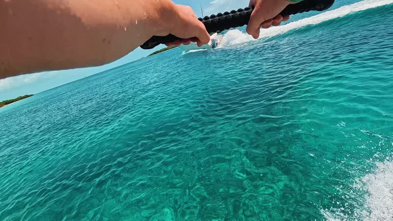 Action camera shot of tourist wakeboarding behind wakeboat