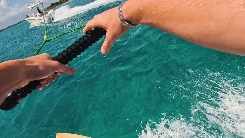 Action camera shot of tourist wakeboarding behind wakeboat