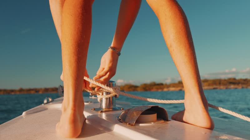 Slow-motion shot of boat operator tying rope