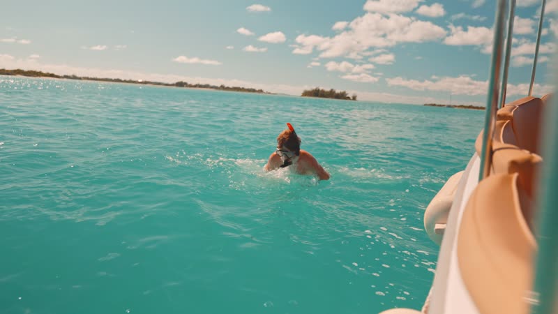 Slow-motion shot of swimmer alongside boat