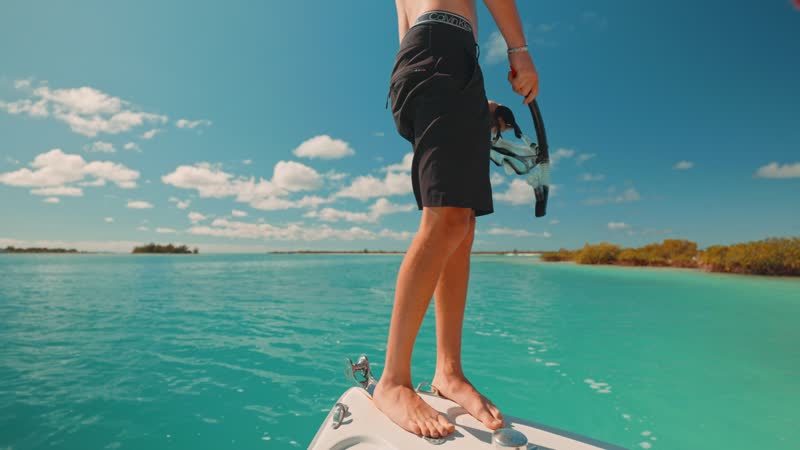 Slow-motion shot of tourist jumping into water from front of boat