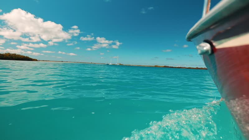 Handheld low angle shot of boat cruising through Leeward waters