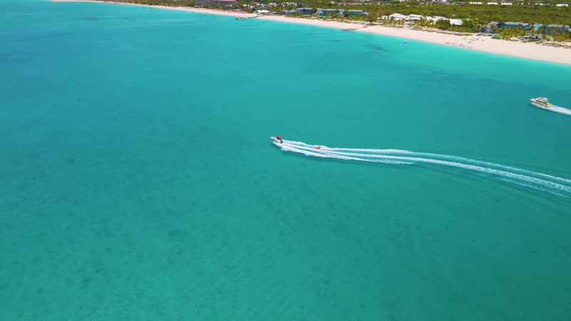Drone shot of a boat pulling a tube near Grace Bay Beach