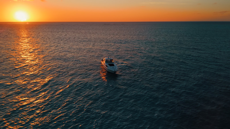 Drone pull-away of a luxury yacht during sunset near Grace Bay