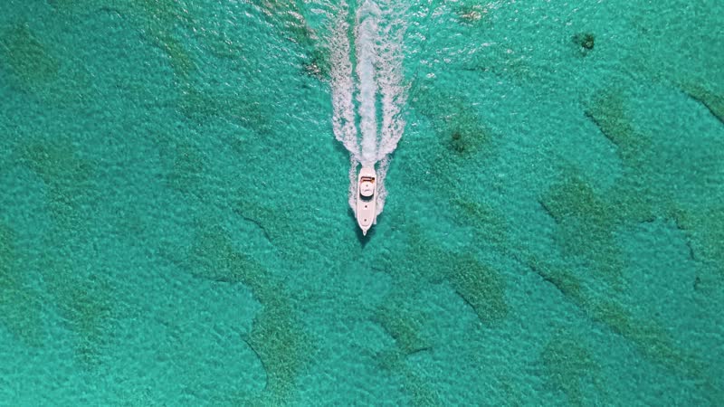 Top down drone shot of luxury yacht cruising through calm Grace Bay waters