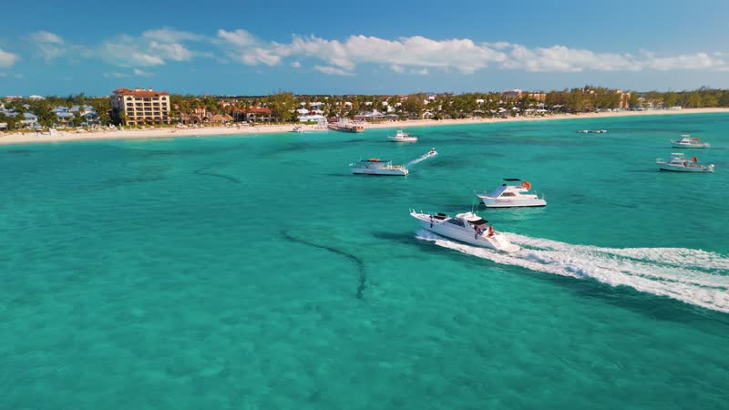 Panning drone shot of luxury yacht arriving at dock on Grace Bay Beach