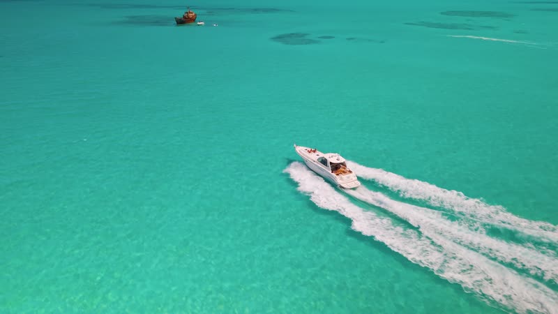 Dynamic drone shot of luxury yacht arriving at the shipwreck