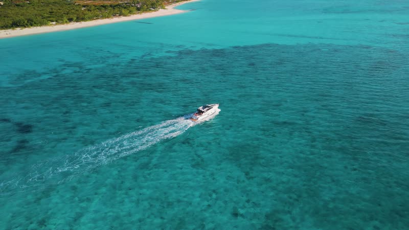 Aerial view of luxury yacht cruising through clear Grace Bay Waters