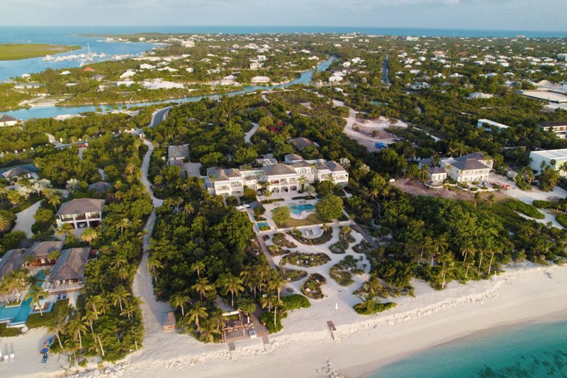 Drone pan of Leeward beachfront villa surrounded by greenery
