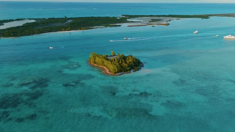 Drone shot revolving around Star Island with boats passing by in the background