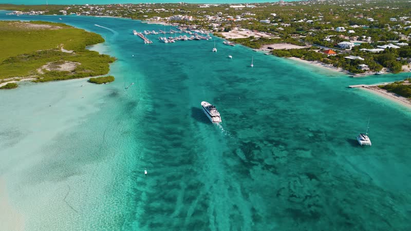 Aerial view of a large luxury yacht arriving at Blue Haven Marina