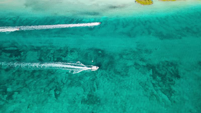 Aerial view of yachts and jetskis heading towards Blue Haven Marina in Leeward