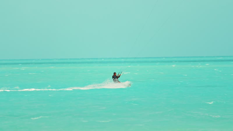 Slow-motion handheld shot of kitesurfers in Long Bay
