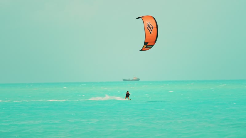 Slow-motion handheld shot of kitesurfers in Long Bay