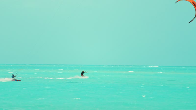 Slow-motion handheld shot of kitesurfers in Long Bay