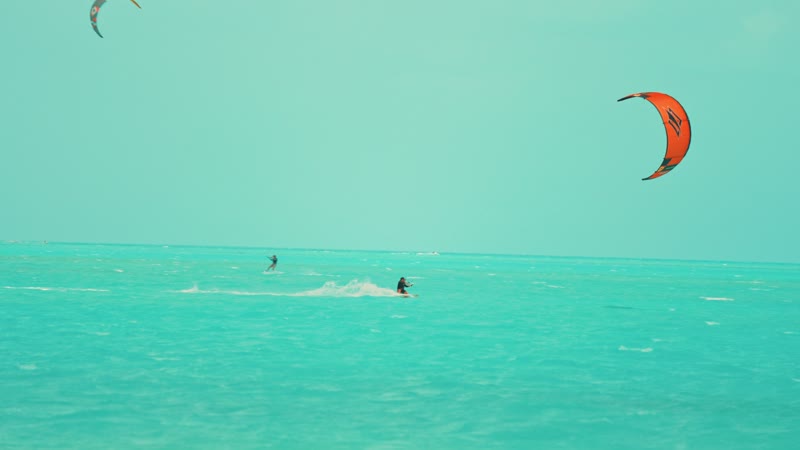 Slow-motion handheld shot of kitesurfers in Long Bay