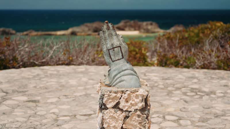 Handheld shot of famous praying statue in Mudjin Harbor, Middle Caicos