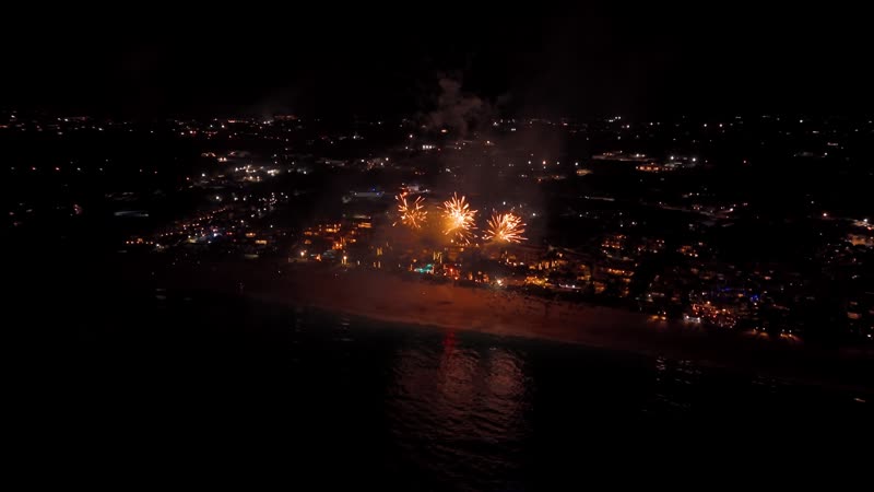 Nighttime drone shot of fireworks over Grace Bay Beach during New Years Eve