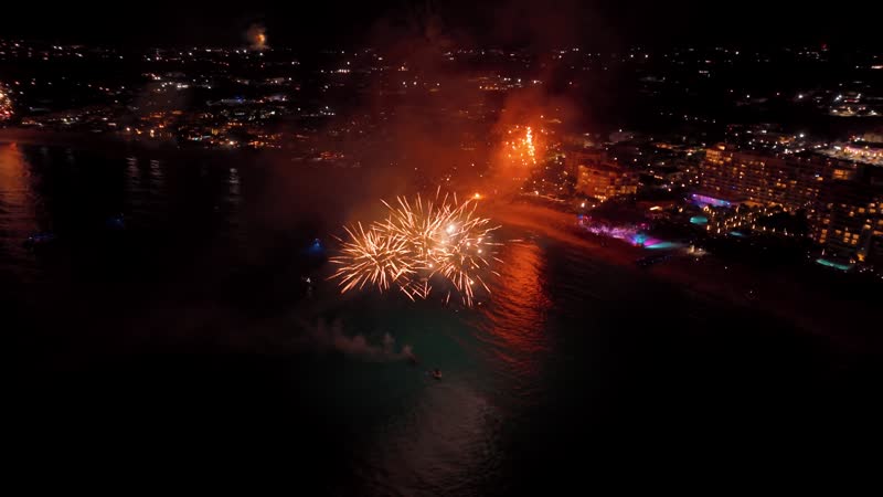 Nighttime drone shot of fireworks over Grace Bay Beach during New Years Eve
