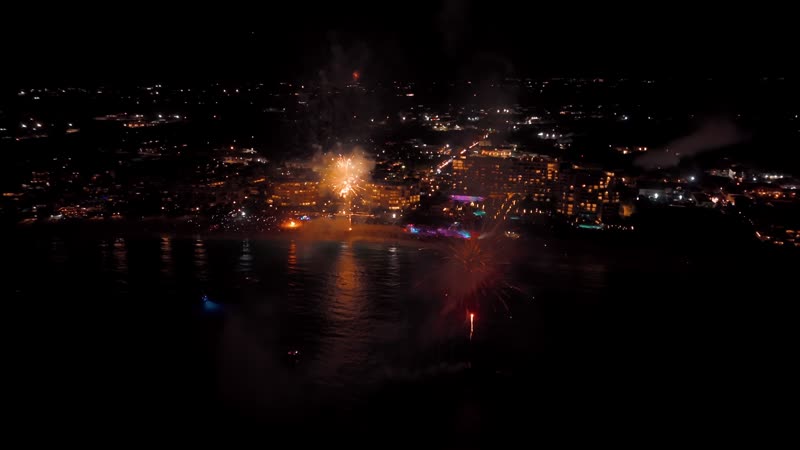 Nighttime drone shot of fireworks over Grace Bay Beach during New Years Eve