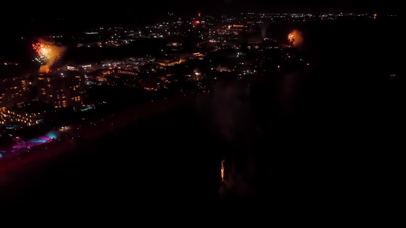 Nighttime drone shot of fireworks over Grace Bay Beach during New Years Eve