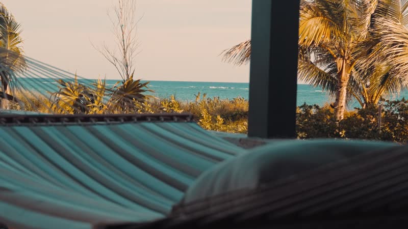Slow-motion shot of hammock swaying with beach in background